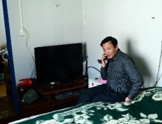 　张国强在自己简易的宿舍内与家人通话

