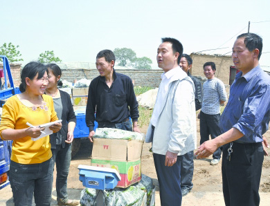   裴春亮（右二）幫助菜農銷售黃瓜。