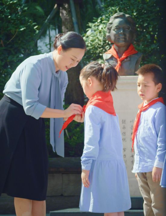 楊浪浪為學生佩戴紅領巾。（受訪者供圖）