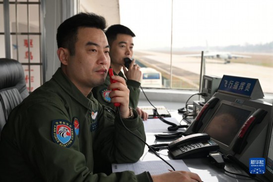 空軍航空兵某團飛行二大隊大隊長張斌（左）在塔台指揮訓練（2023年2月16日攝）。新華社發（余紅春 攝）