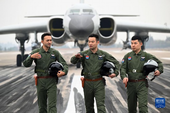 空軍航空兵某團飛行二大隊大隊長張斌（中）與機組成員交流（2023年2月18日攝）。新華社發（余紅春 攝）