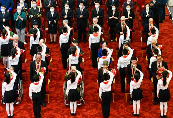 2021年6月29日，慶祝中國共產黨成立100周年“七一勛章”頒授儀式在北京人民大會堂金色大廳隆重舉行。這是少先隊員向勛章獲得者獻花，敬禮致意。新華社記者 高潔 攝
