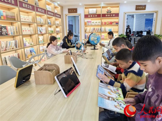 阿依丁庫勒村圖書館內，孩子們正在閱讀。人民網記者 陳新輝攝